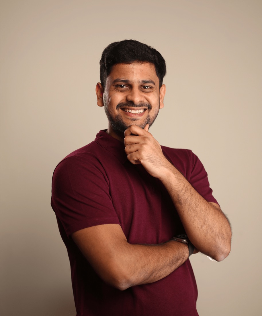 Pankaj Bokdia, smiling, hand on his chin, in a maroon shirt.